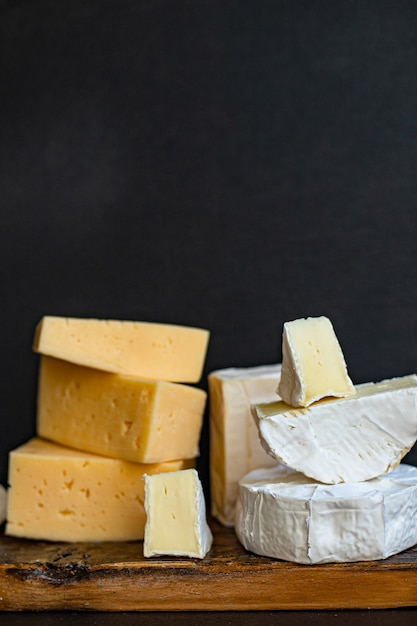 Assortiment de fromages savoureux sur une planche de bois