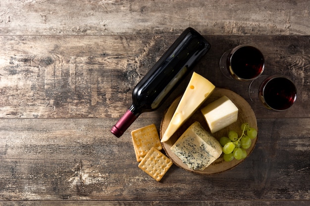 Assortiment de fromages et de vin sur une table en bois. Vue de dessus. Espace de copie