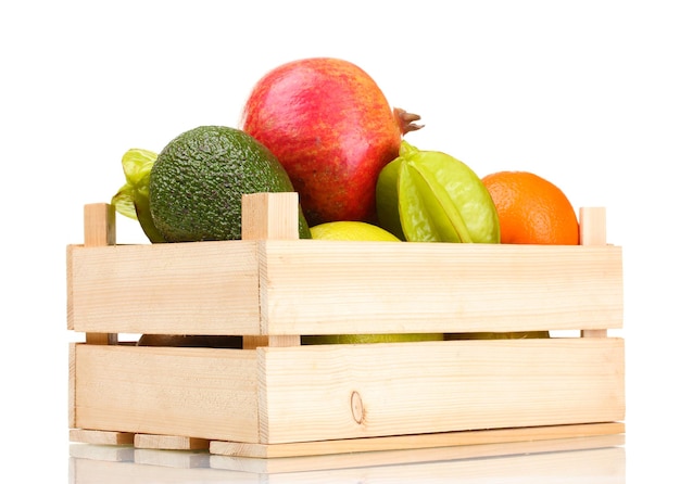 Photo assortiment de fruits exotiques dans un coffret en bois isolé sur blanc