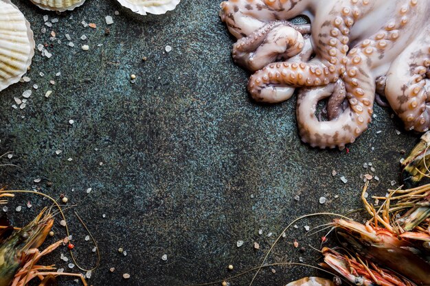 Assortiment de fruits de mer avec poulpe, pétoncles et crevettes crus frais, comme arrière-plan de dîner gastronomique
