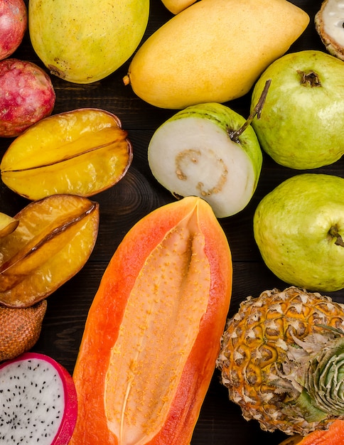 Assortiment de fruits tropicaux thaïlandais sur un fond rustique en bois foncé.