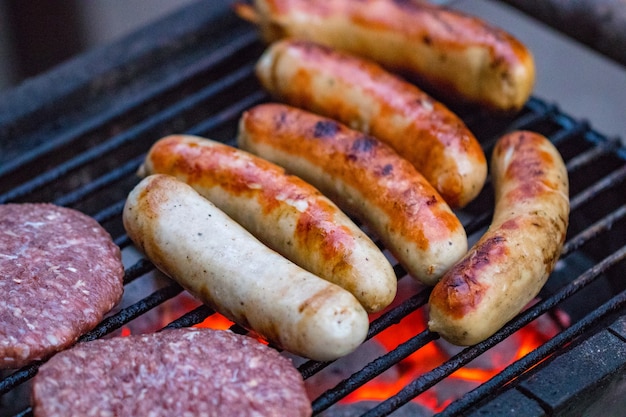 Assortiment de grillades à base de viande de poulet et de porc, saucisses rôties sur une grille de barbecue cuites pour le dîner d'été en famille.