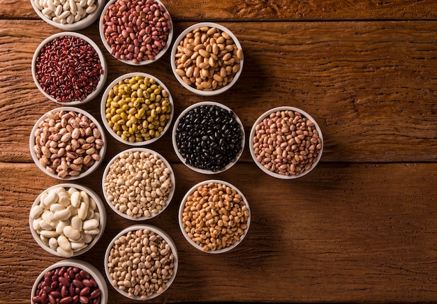 Assortiment de haricots dans des bols sur table en bois