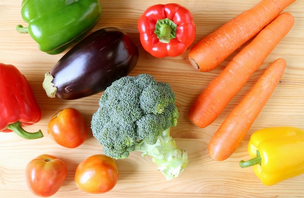 Assortiment de légumes frais colorés éparpillés sur fond de bois