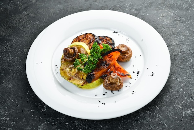 Assortiment de légumes grillés champignons poivrons paprika courgettes et aubergines sur une assiette Vue de dessus