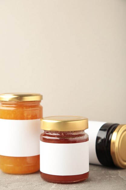 Assortiment de maquettes de pots de confiture. Pots avec étiquette vierge sur gris. Photo verticale