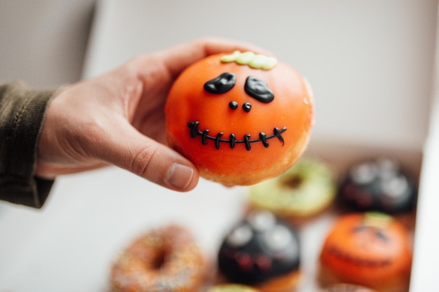 Assortiment de monstres d'halloween avec des beignets de grimaces dans une boîte à l'intérieur de la maison