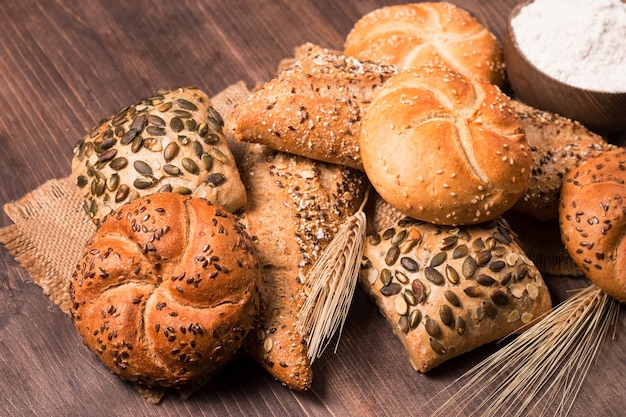 Assortiment de pain cuit au four avec des graines sur un fond de table en bois. Pâtisserie. Notion de sécurité alimentaire.