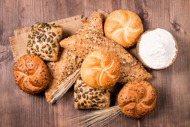 Assortiment de pain cuit au four avec des graines sur un fond de table en bois. Pâtisserie. Notion de sécurité alimentaire.