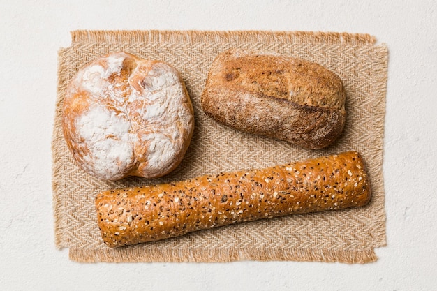 Assortiment de pain fraîchement cuit avec une serviette sur la vue de dessus de table rustique Pain sans levain sain Pain français