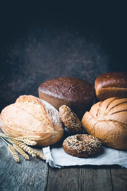 Assortiment de pain et petits pains frais sur fond de table en bois