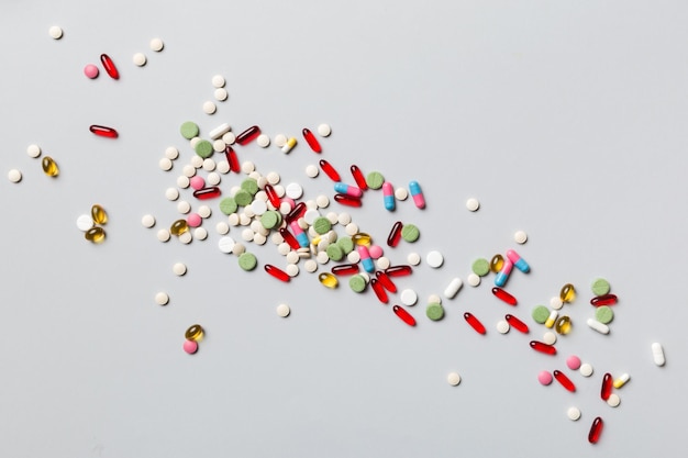 Assortiment de pilules et de comprimés bordure supérieure sur fond coloré De nombreuses pilules différentes et espace pour le texte sur la vue de dessus de fond coloré
