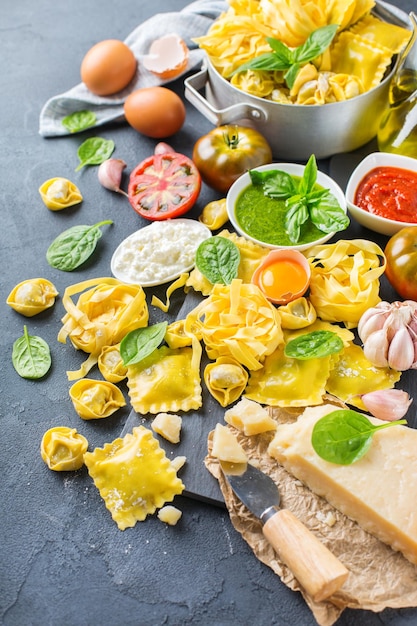 Assortiment de plats italiens et d'ingrédients raviolis à la ricotta et aux épinards pâtes tortellini pesto sauce tomate huile d'olive parmesan