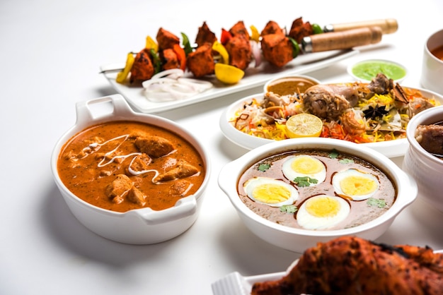 Assortiment de recettes indiennes non végétariennes servies en groupe. Comprend poulet au curry, mouton masala, anda ou curry aux œufs, poulet au beurre, biryani, tandoori murg, poulet-tikka et naa, roti pour le ramadan