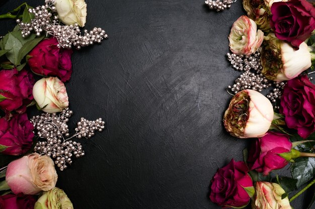 Assortiment de roses rouges et roses à décor de perles argentées sur fond sombre. Belle conception florale. Amour et beauté. Concept de fond