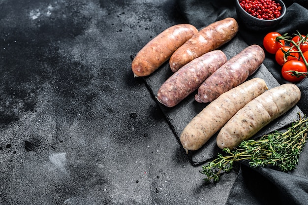 Assortiment de saucisses de porc, de bœuf et de poulet crus frais assortis d'épices.