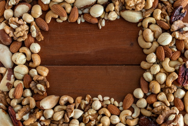 Assortiment de savoureuses noix sur fond de bois. Cadre. Vue de dessus. Espace libre pour votre texte.