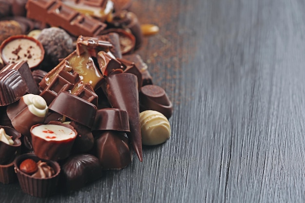 Assortiment de savoureux bonbons au chocolat sur fond de table en bois