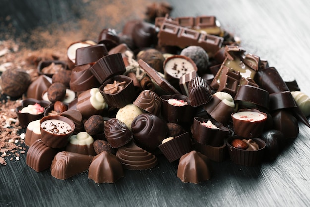 Assortiment de savoureux bonbons au chocolat sur fond de table en bois