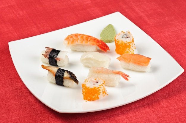 Assortiment de sushis allongés sur la plaque carrée blanche