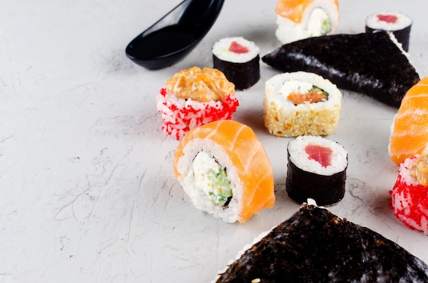 Assortiment de sushis et rouleaux différents avec sauce soja, gingembre, wasabi et baguettes