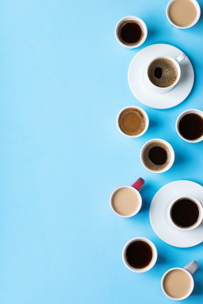 Assortiment de tasses à café et mugs avec torréfaction noire, americano, cappuccino, lait sur fond bleu. Mise à plat de l'espace de copie à la mode créatif