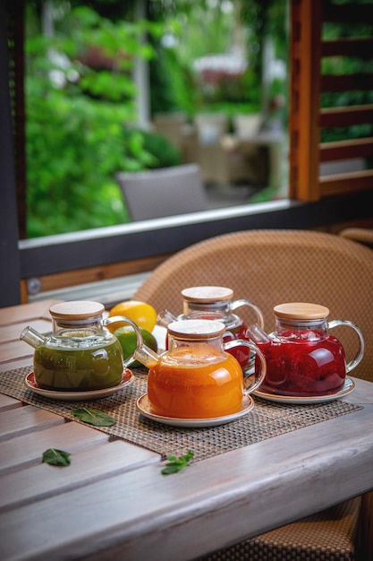 Un assortiment de thés en théières en verre sur la terrasse d'été du restaurant Ginger argousier et thé aux fruits