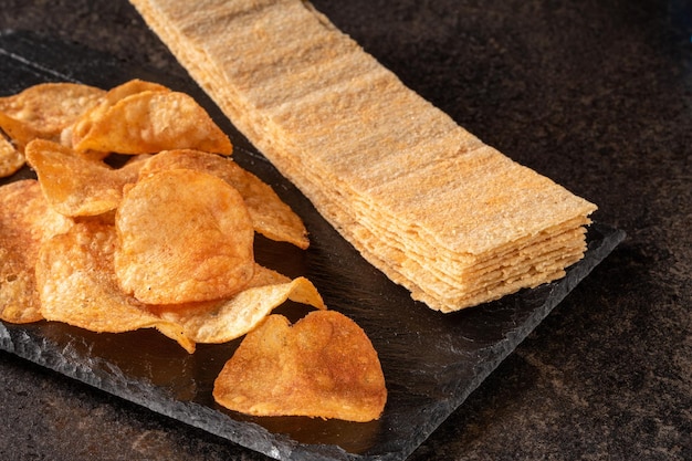 Assortiment de tranches de chips de pomme de terre et de chips sur un fond sombre