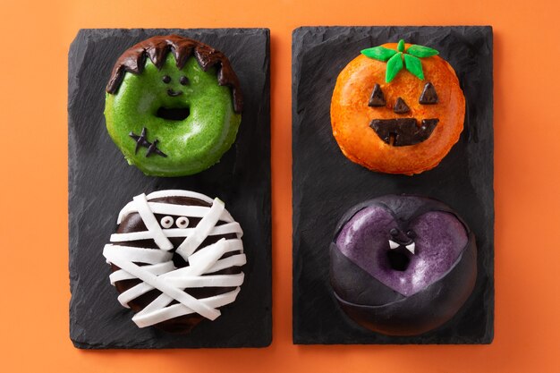 Photo assortmen de beignets d'halloween sur fond orange