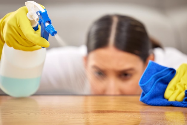 Assurez-vous d'être minutieux Photo d'une jeune femme pulvérisant du nettoyant sur sa table basse