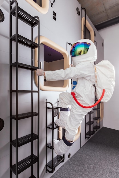 Photo l'astronaute en combinaison spatiale va dormir dans un hôtel capsule