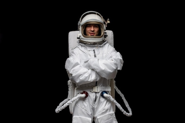 Astronaute jour gars astronaute isolé en costume de combinaison spatiale fond noir visage ouvert mains croisées