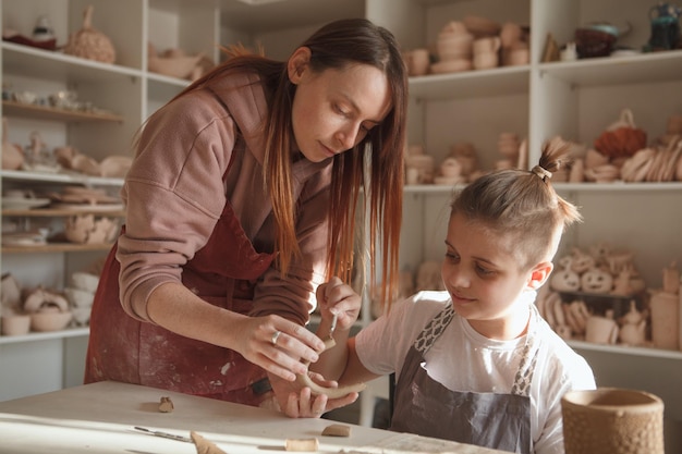 Atelier d'art d'enseignement de potier féminin pour un jeune garçon