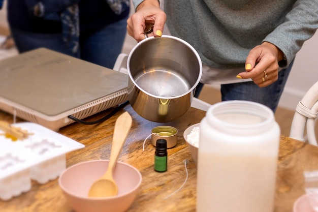 Atelier de bougies à la cire de soja à la main Jeune fille versant de la cire liquide