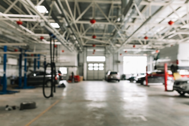 Photo atelier de carrosserie avec des voitures au travail