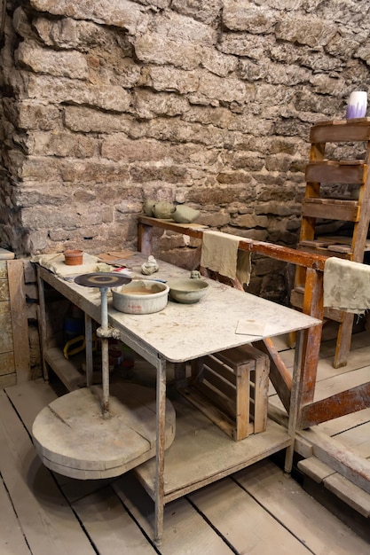 L'atelier Du Potier. Une Table De Travail Avec De L'argile Et Un Tour De Potier.