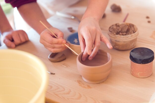 Photo atelier de poterie pour enfants fille travaillant avec de l'argile