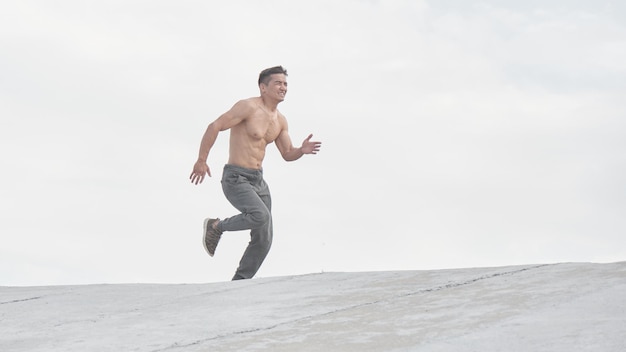 Athlète asiatique faisant du jogging le matin à l'extérieur, style de photo minimalisme de coureur kazakh