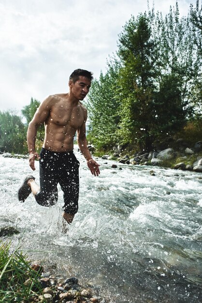 Athlète asiatique lors d'une course matinale sur la rivière, jogger kazakh en gros plan nature