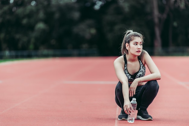L'athlète la belle fille asiatique une pause dans l'exécution du concept de femme fatiguée