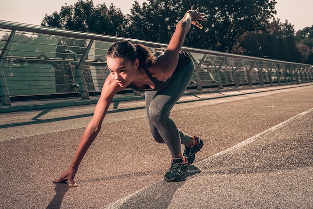 L'athlète concentré à l'accroupissement commence à avoir l'air confiant avant de courir