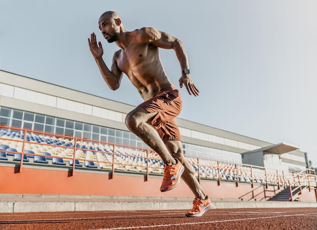 Athlète coureur africain sprintant sur une piste de course au stade