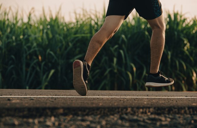 Athlète de coureur d'homme sur la route à la santé, jeunes exécutant l'exercice sur la rue