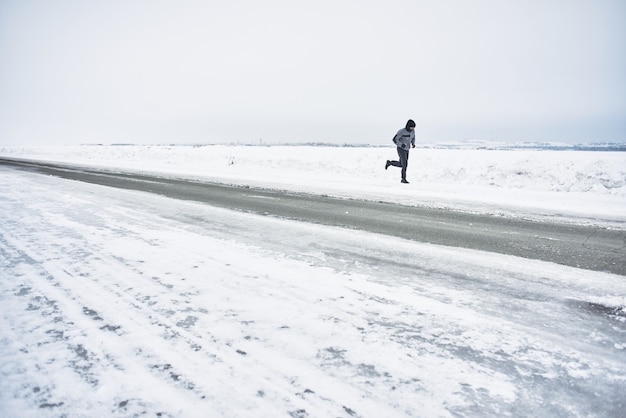 L'athlète court en hiver sur la route