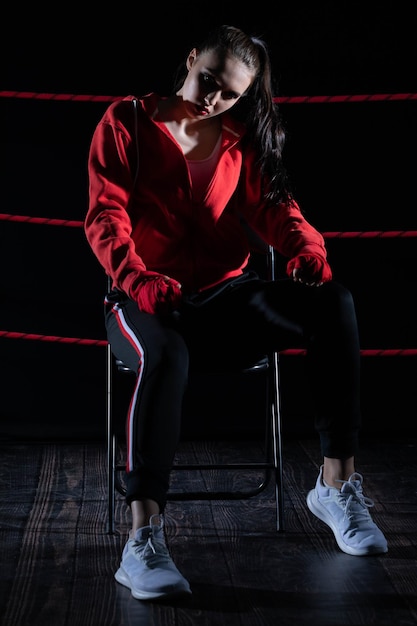 L'athlète est assis sur une chaise dans le ring de boxe après avoir perdu le combat malgré la préparation technique l'athlete a perdu le combat en sweatshirt