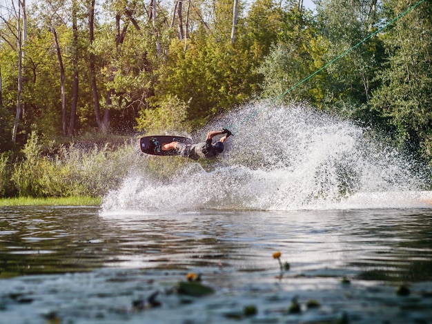 Un athlète exécute un tour de wakeboard avec des éclaboussures d'eau