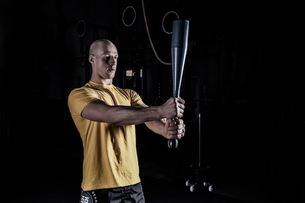 Photo athlète faisant de l'exercice avec clubbel au gymnase