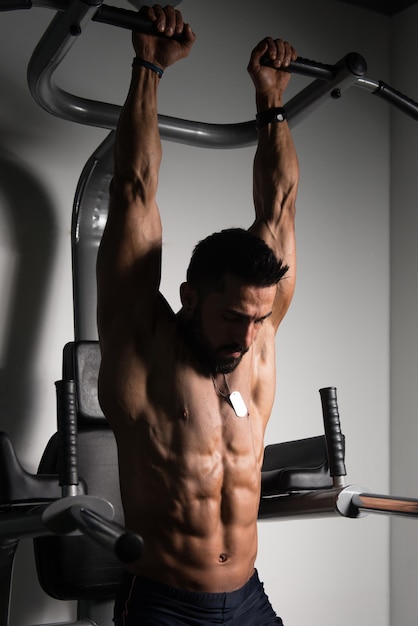 Athlète faisant des exercices abdominaux de barre de traction dans la salle de gym