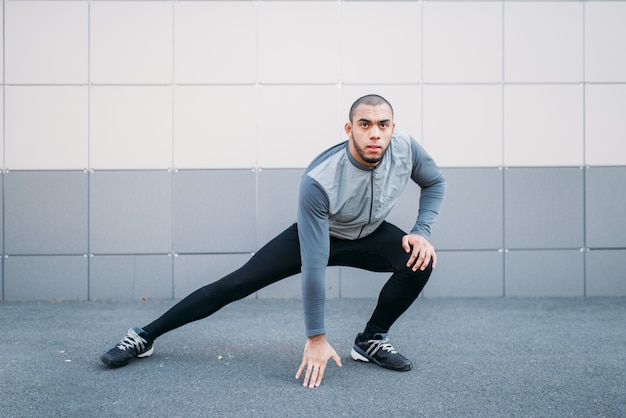 Athlète faisant des exercices d'étirement avant de courir