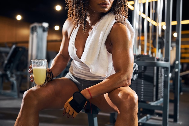 Athlète féminine aux cheveux bouclés avec une boisson saine